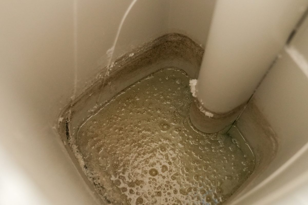 Mineral scale and buildup left by hard water inside a cistern